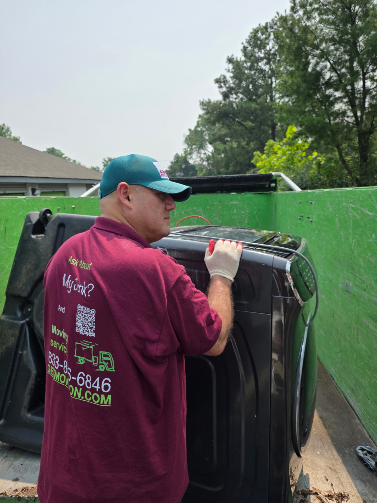 Movin On team member loading a heavy washer into the truck bed